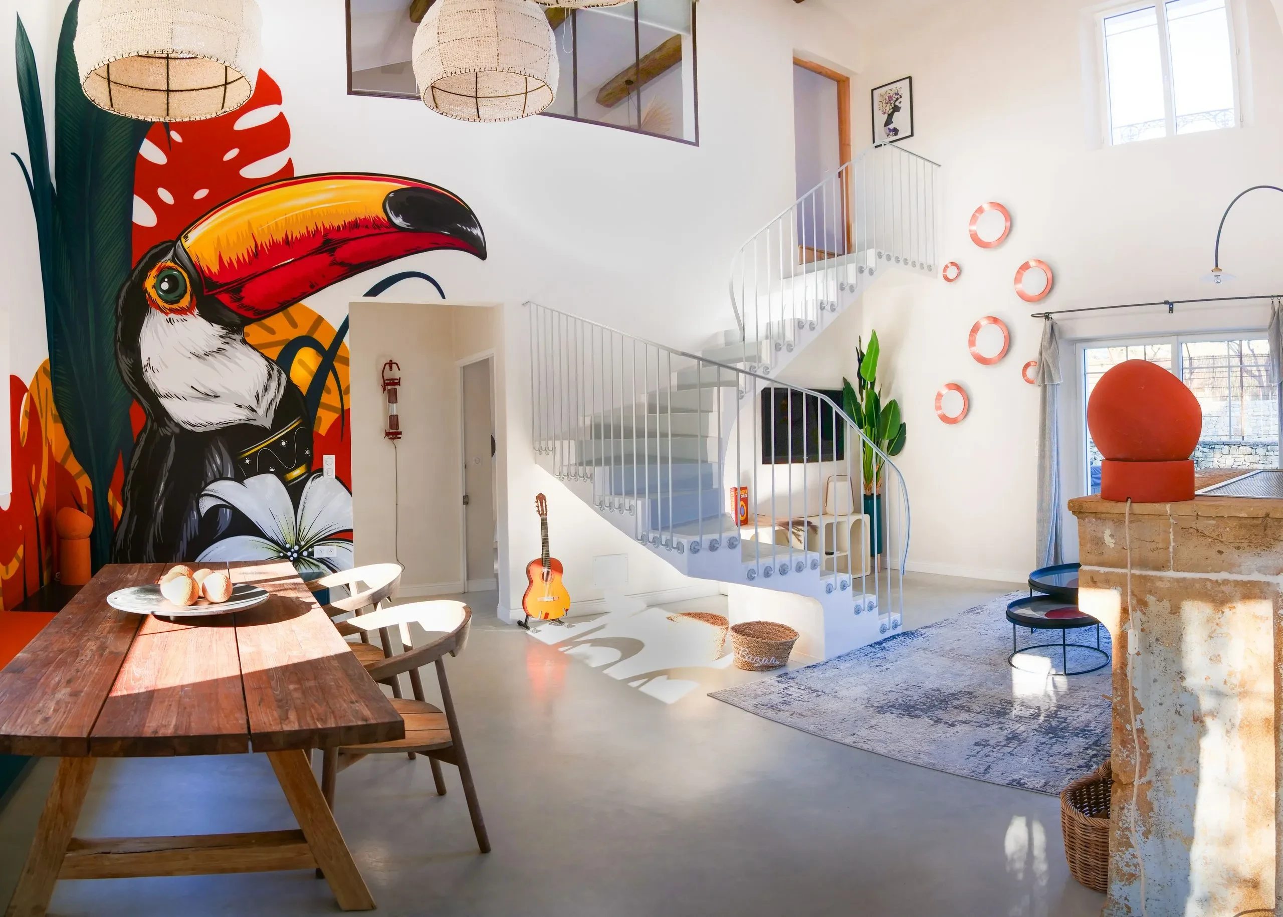 Salon moderne avec peinture murale de toucan coloré.