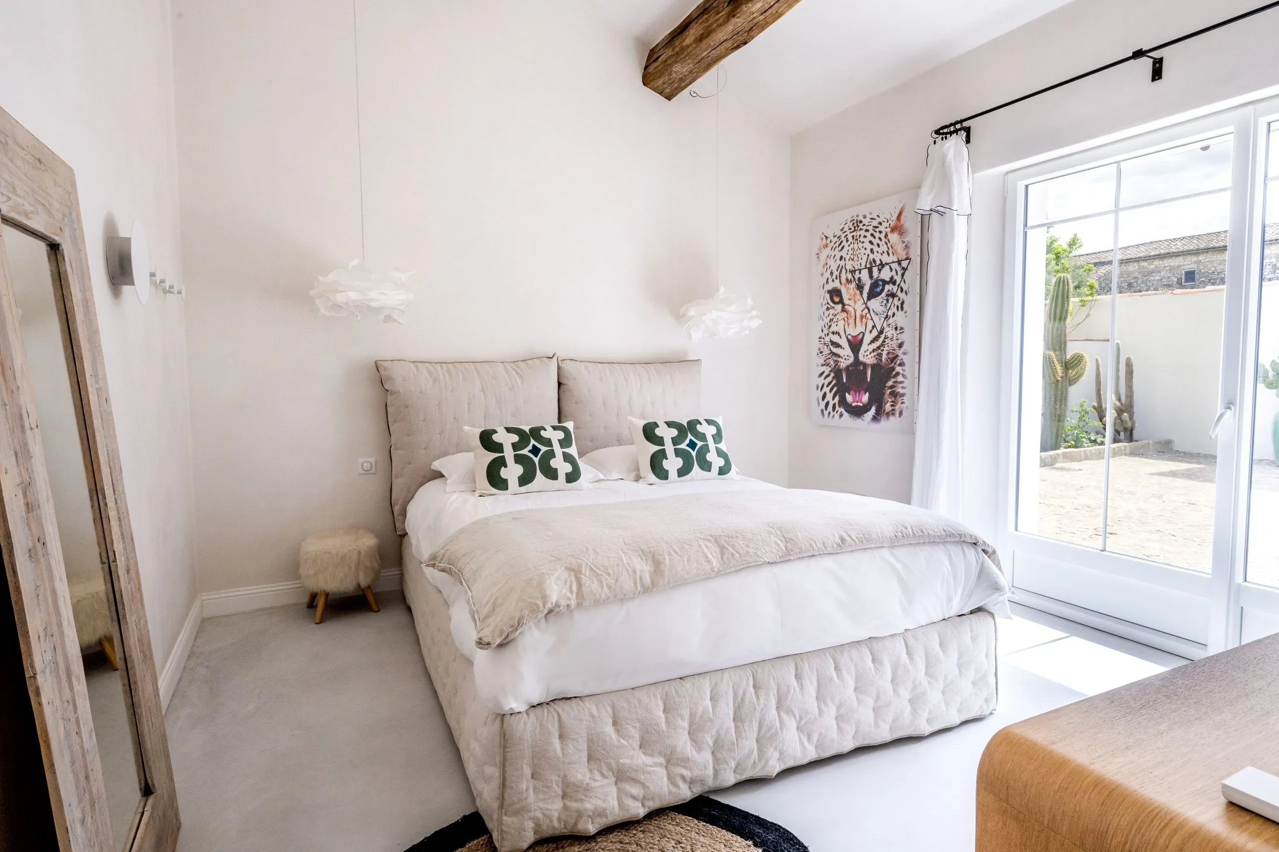 Chambre moderne avec lit double, décoration chic et léopard.
