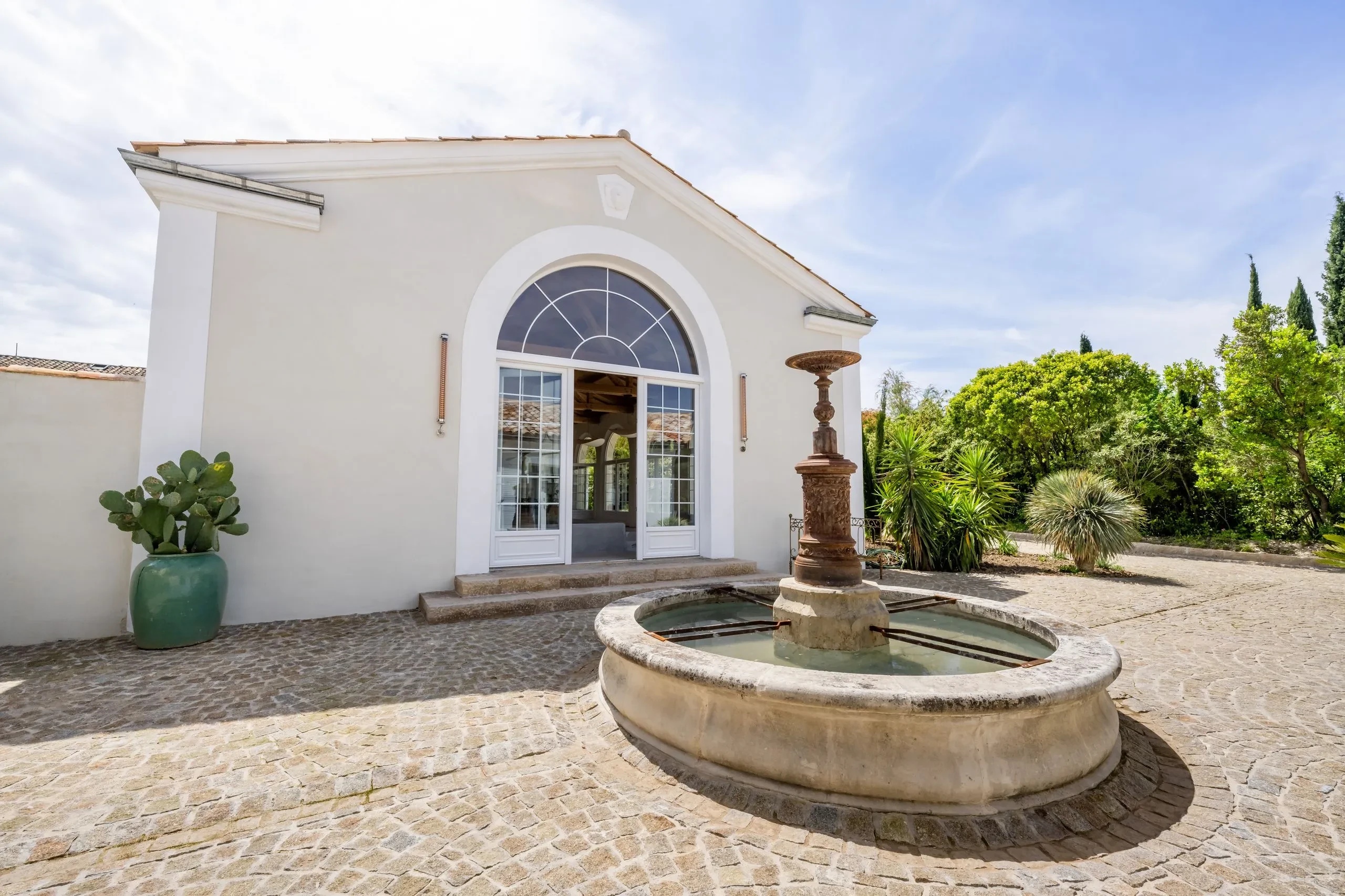 Maison avec fontaine et jardin ensoleillé