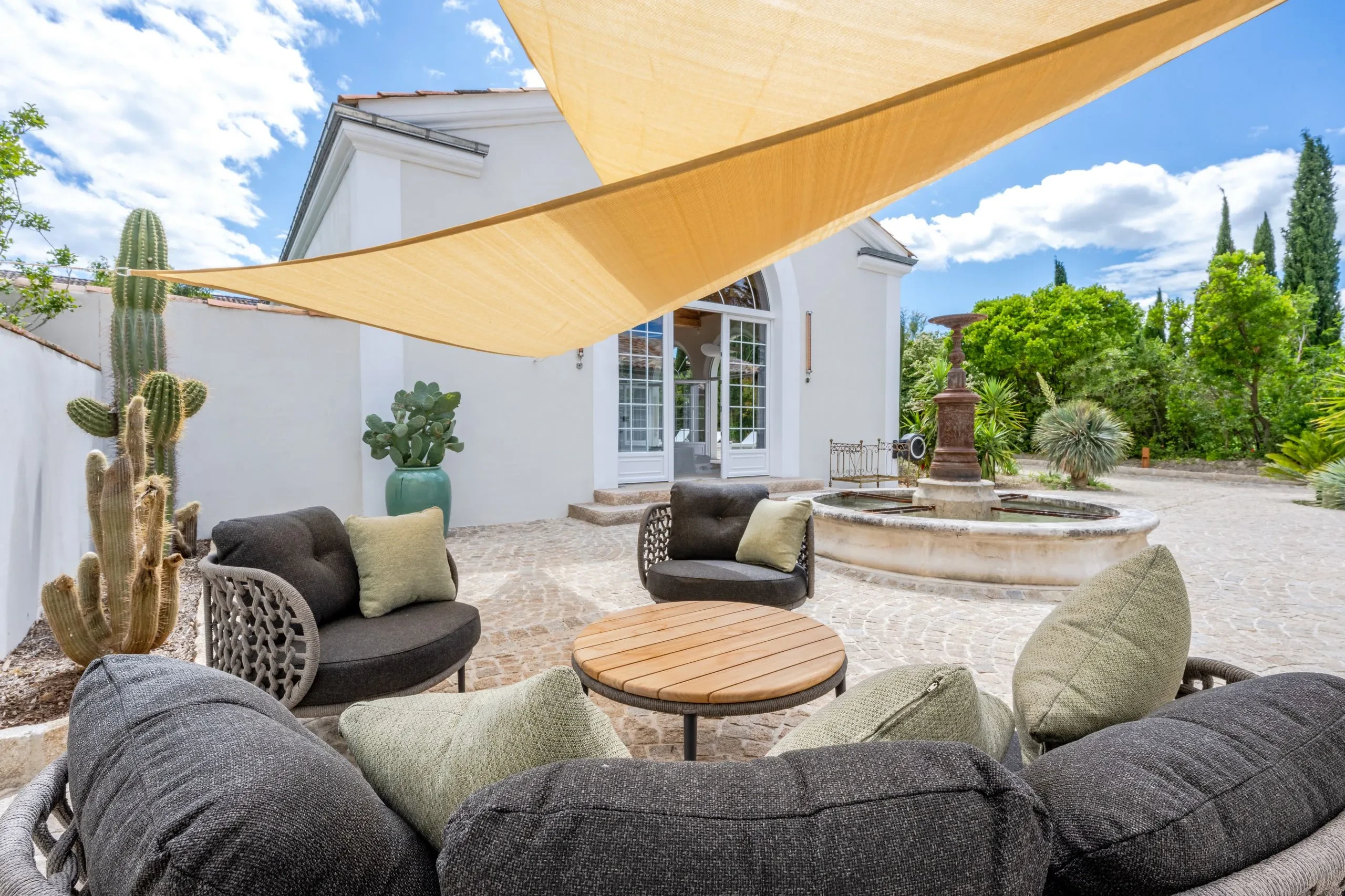 Terrasse avec salon extérieur et fontaine.