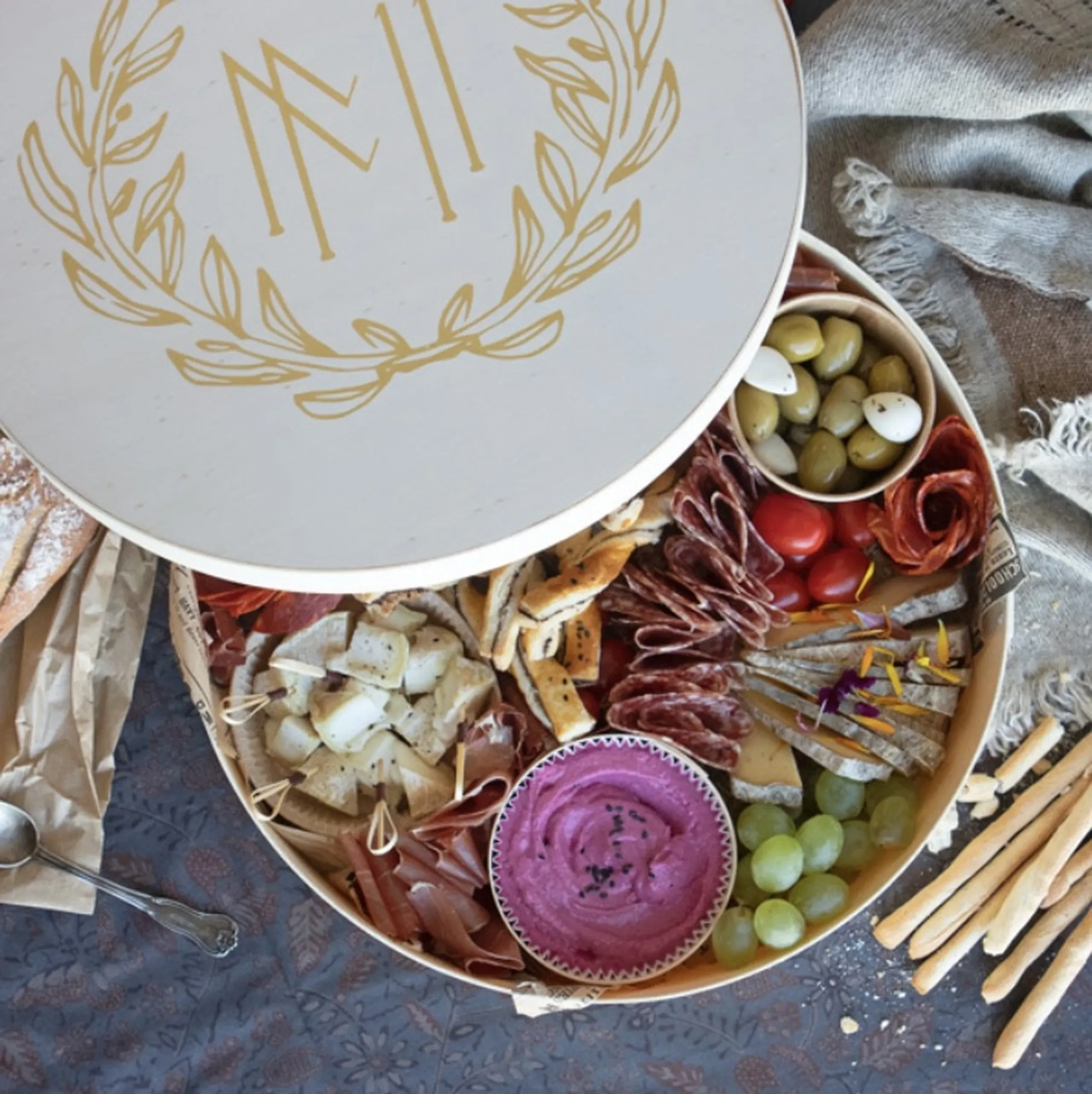 Plateau apéro avec charcuterie et fromage variés.