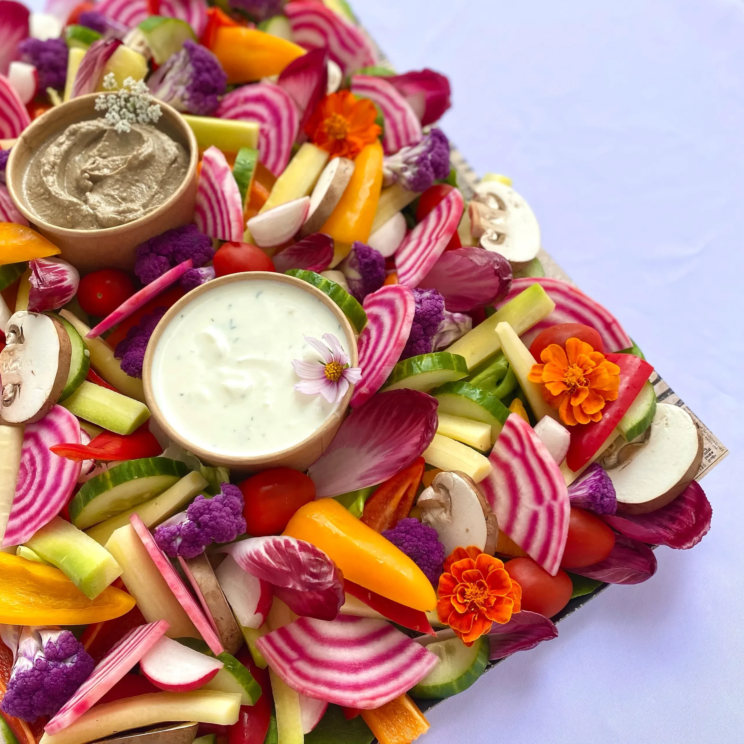 Plateau coloré de légumes frais et sauces variées.