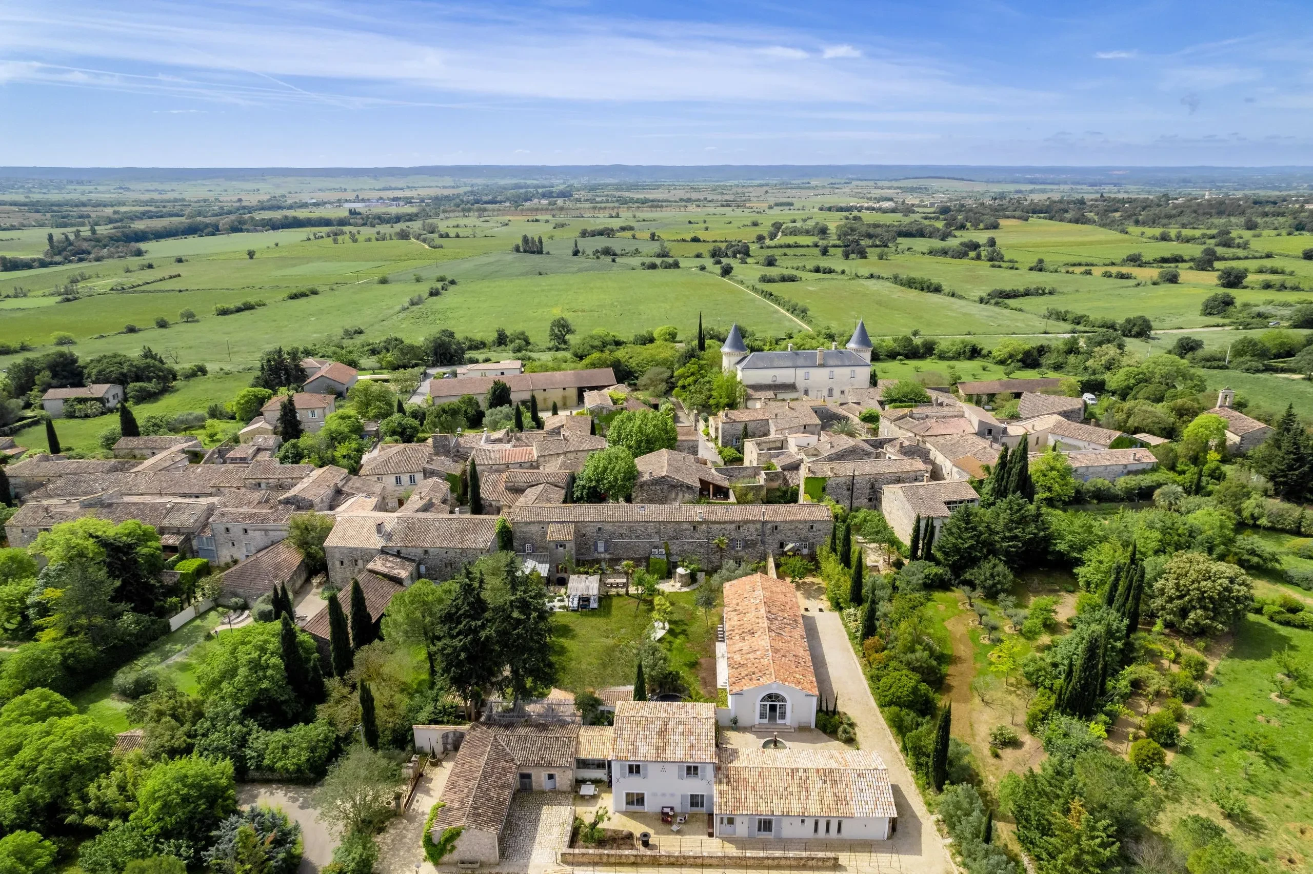 Village médiéval en pierre dans la campagne verte française.
