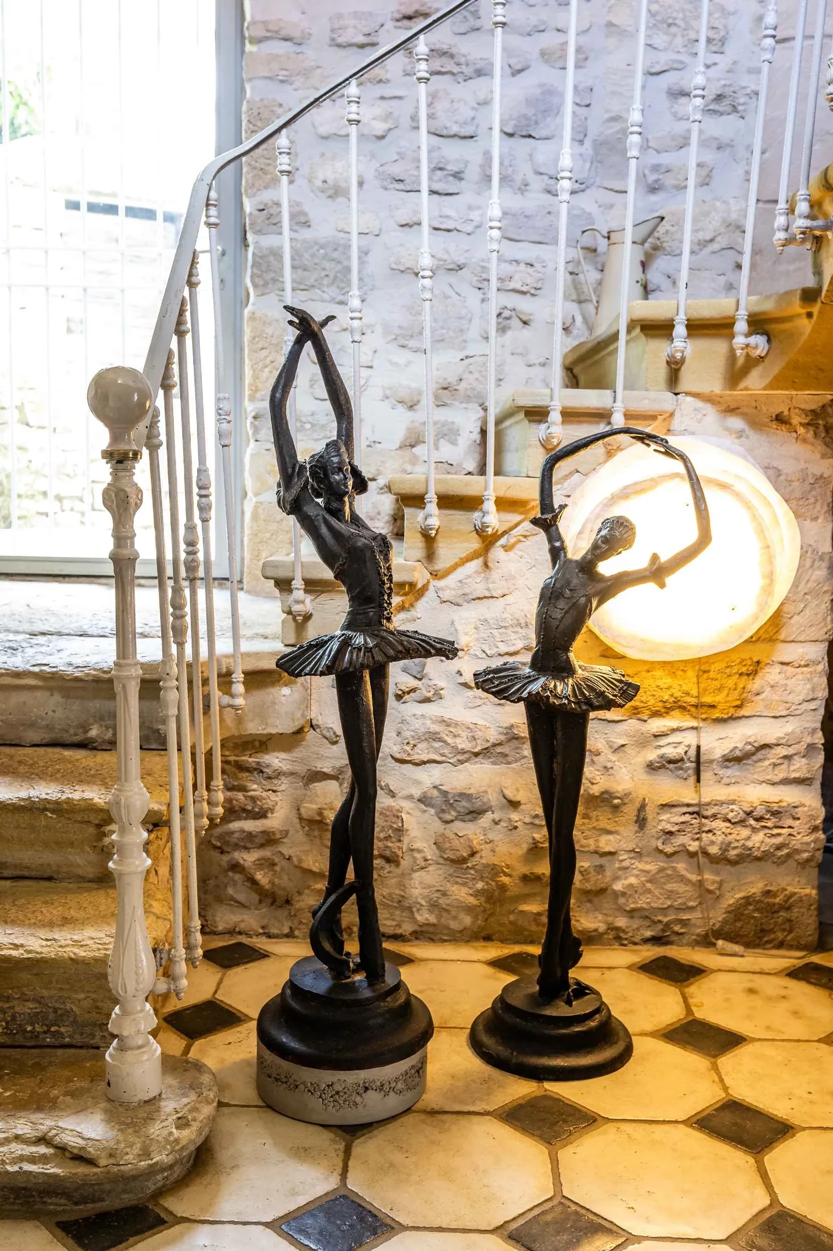 Deux statues de ballerines en intérieur lumineux.