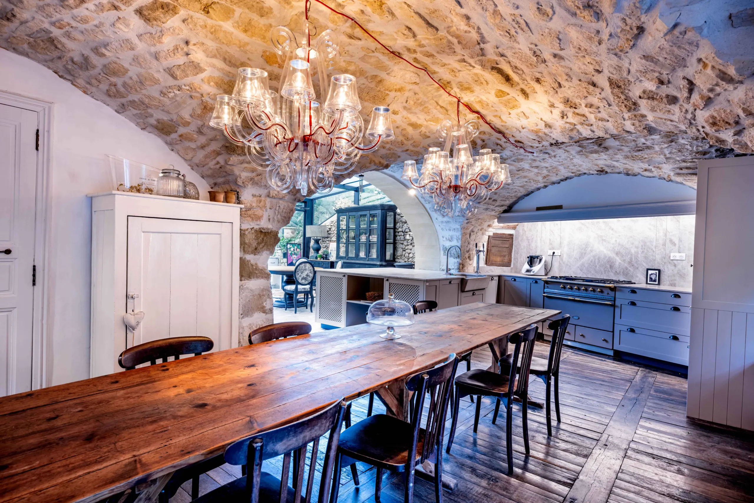 Cuisine rustique avec table en bois et éclairage élégant.