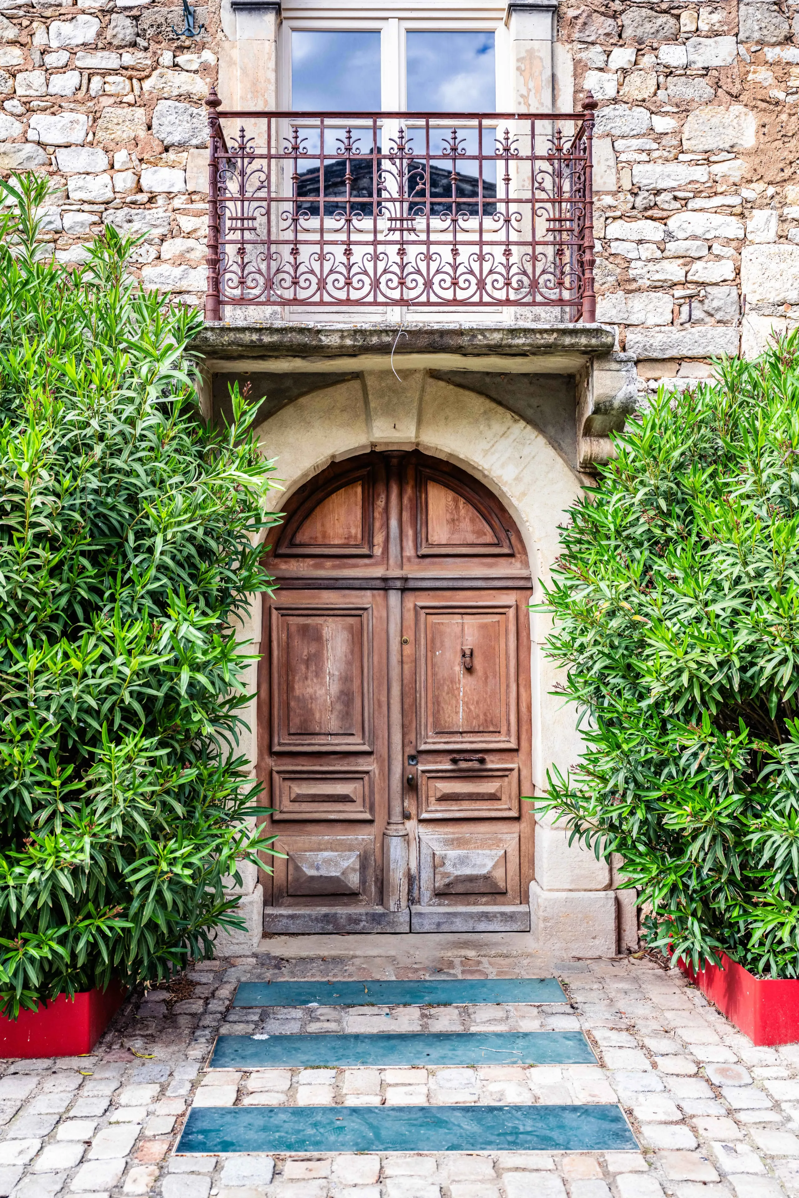 Porte en bois ancienne avec balcon en fer forgé