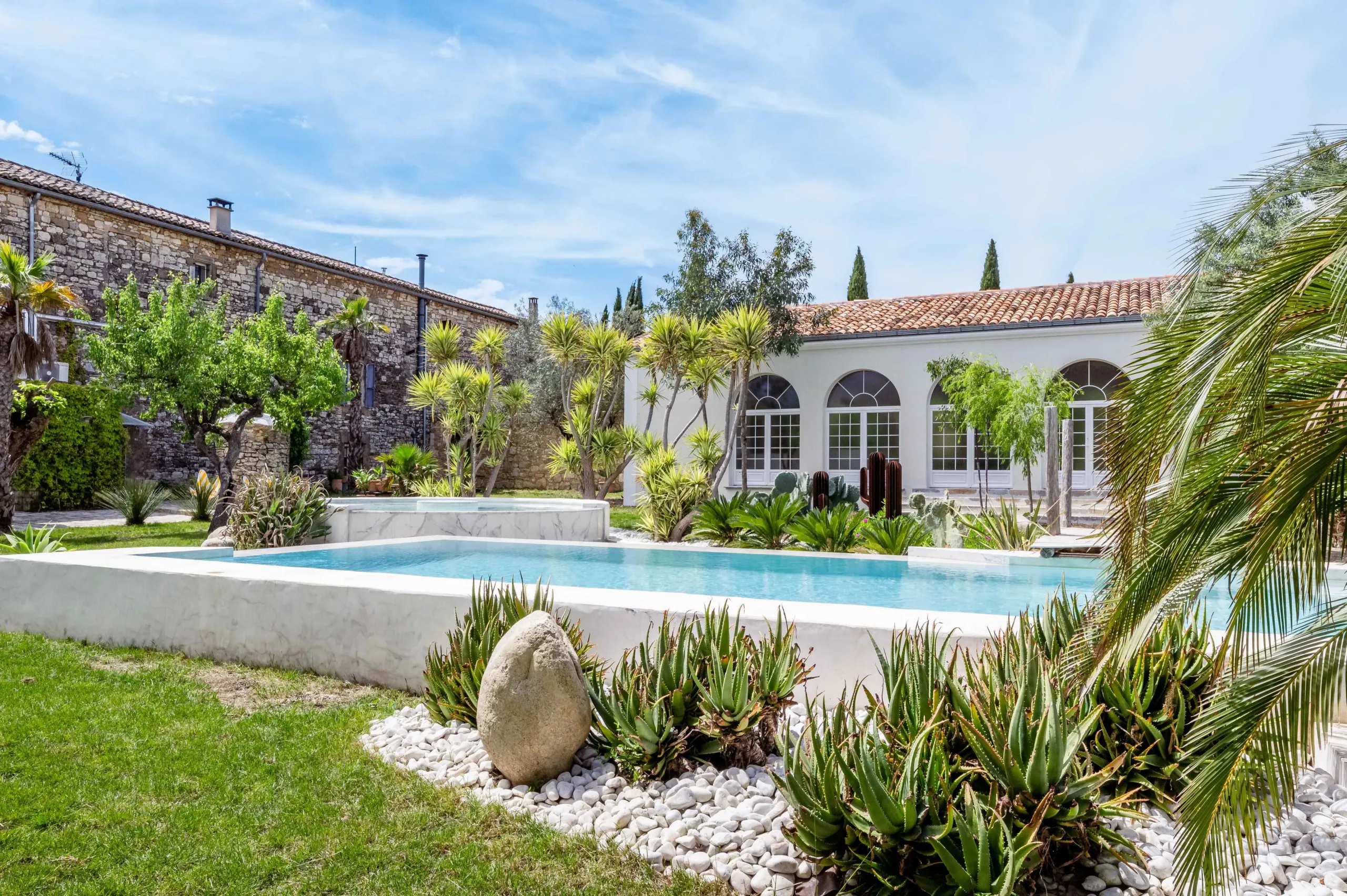 Jardin méditerranéen avec piscine et villa.