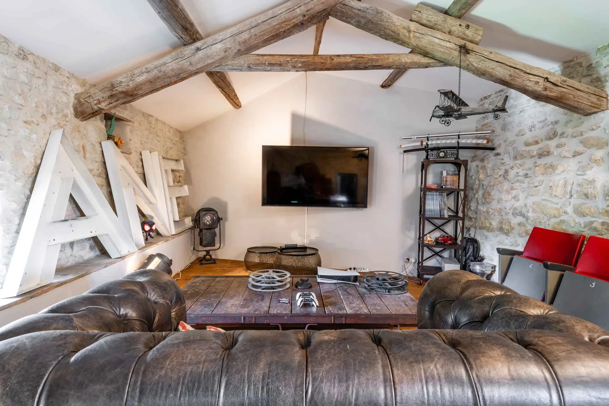Salon moderne avec canapé en cuir et télévision.