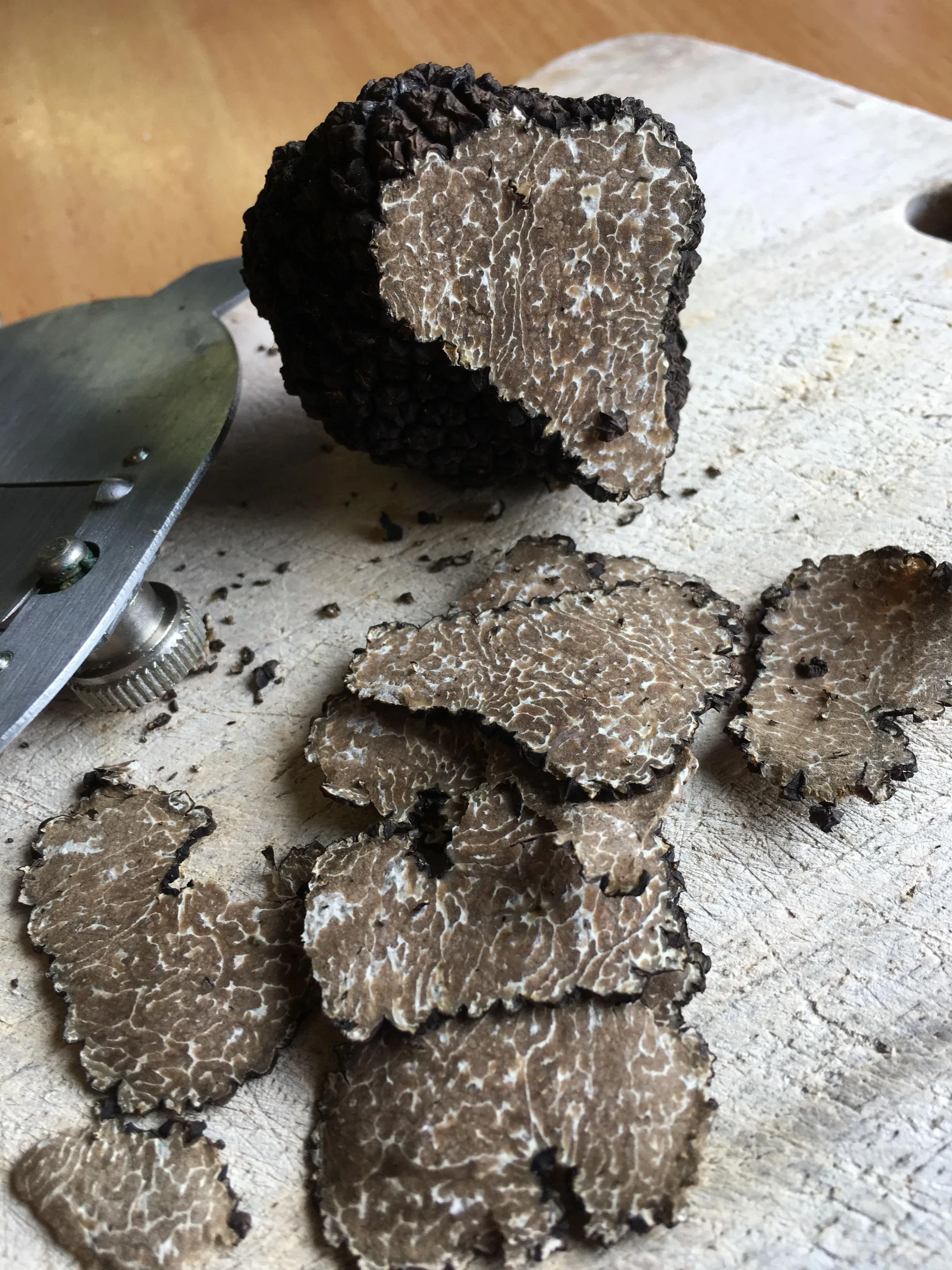 Truffe noire fraîchement tranchée sur une planche.