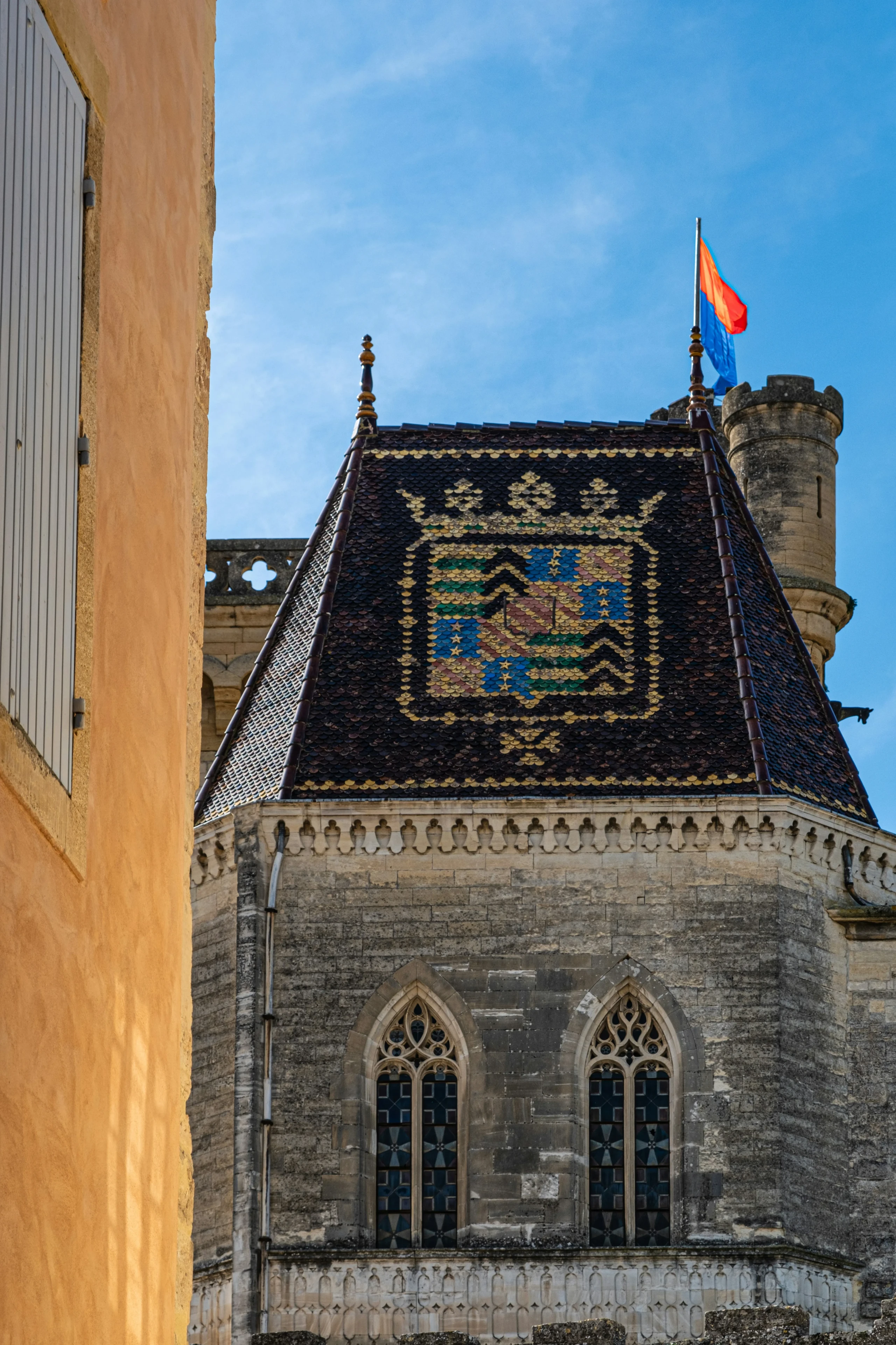 Toit en tuiles colorées avec blason médiéval.